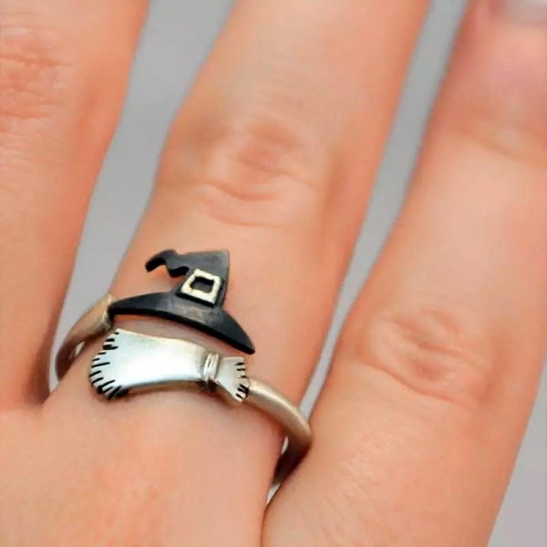 Imagen de anillo con sombrero y escoba de bruja enroscado en dedo