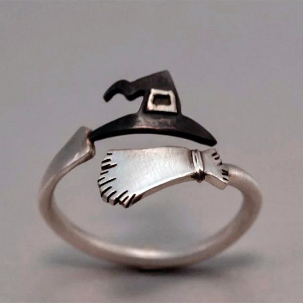 Imagen de anillo con sombrero y escoba de bruja enroscado en dedo